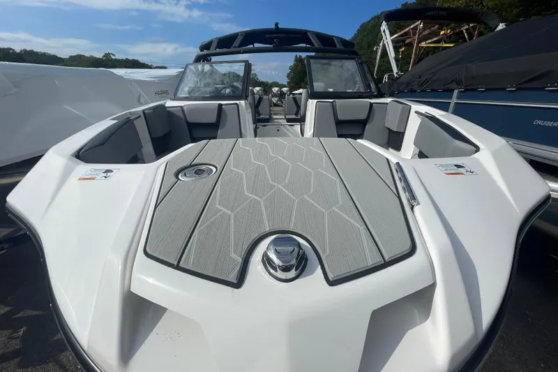 Slide: The Image of 2026 Yamaha Boats 222XD, sleek design, spacious seating, modern features, docked under clear sky. - 2