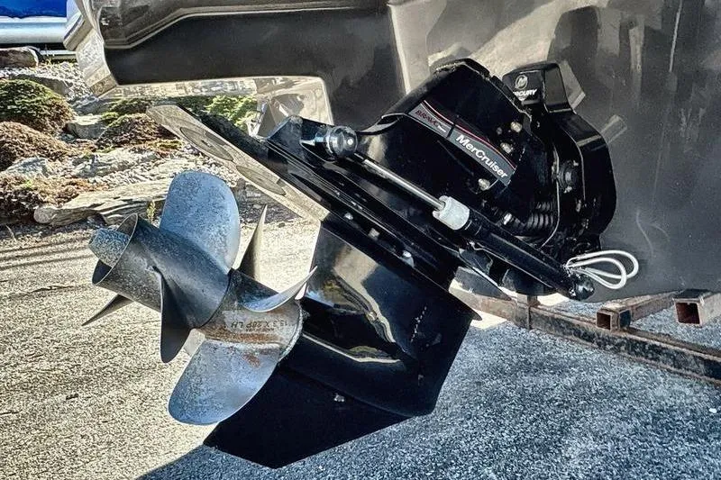 Slide: The Image of 2023 Monterey M6 boat with MerCruiser outdrive and propeller, parked on gravel. - 5