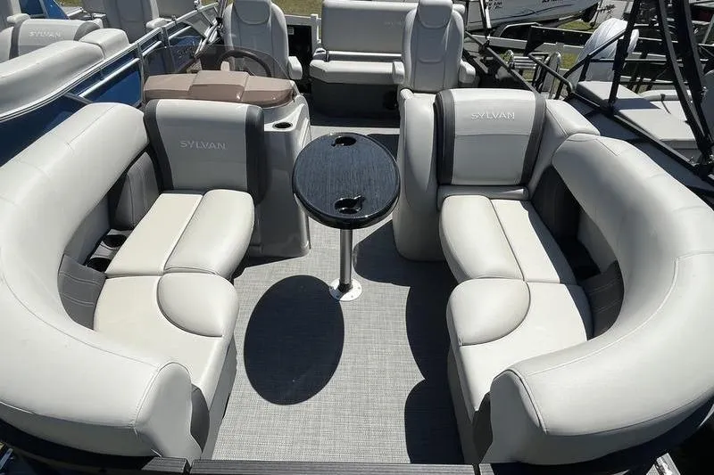 Slide: The Image of 2025 Sylvan Mirage 820 CLZ DH pontoon boat with luxurious seating and central table. - 14