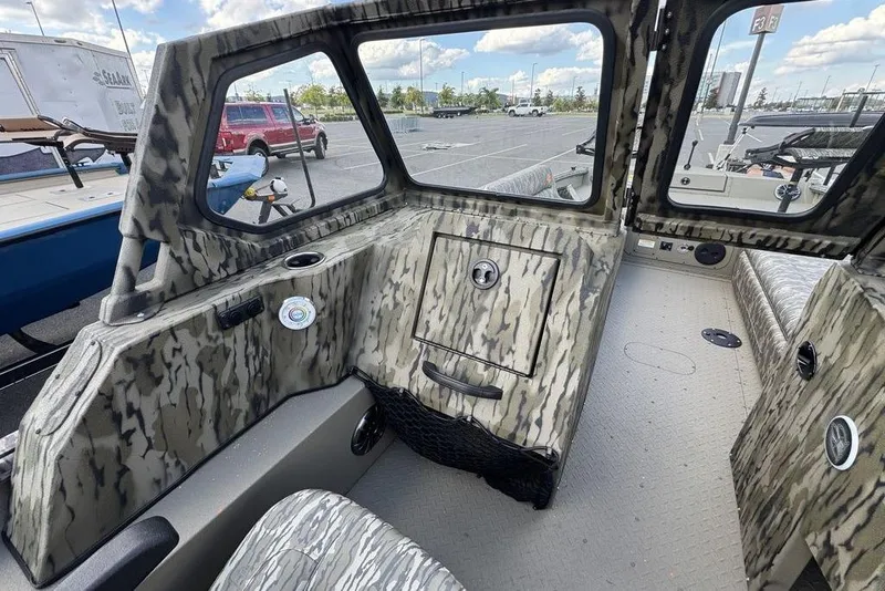 Slide: The Image of 2026 SeaArk EasyCat boat interior with camouflage seating and storage compartments. - 12