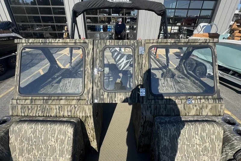 Slide: The Image of 2026 SeaArk EasyCat boat with camouflage design, parked outside a showroom. - 20