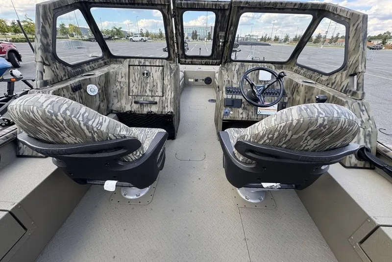 Slide: The Image of 2026 SeaArk EasyCat boat with camouflage seating, parked outdoors. - 5