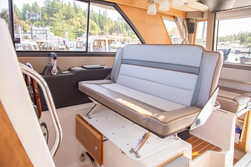 Slide: The Image of Manufacturer Provided Image: Interior of 2025 Cutwater C-32 C boat with modern seating and scenic window view. - 11