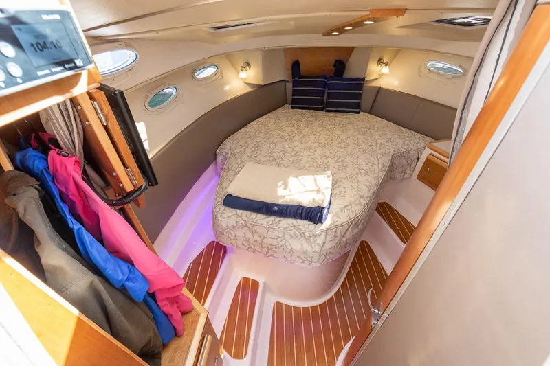 Slide: The Image of Manufacturer Provided Image: Luxurious 2025 Cutwater C-32 C cabin interior with cozy bed and elegant wood flooring. - 13