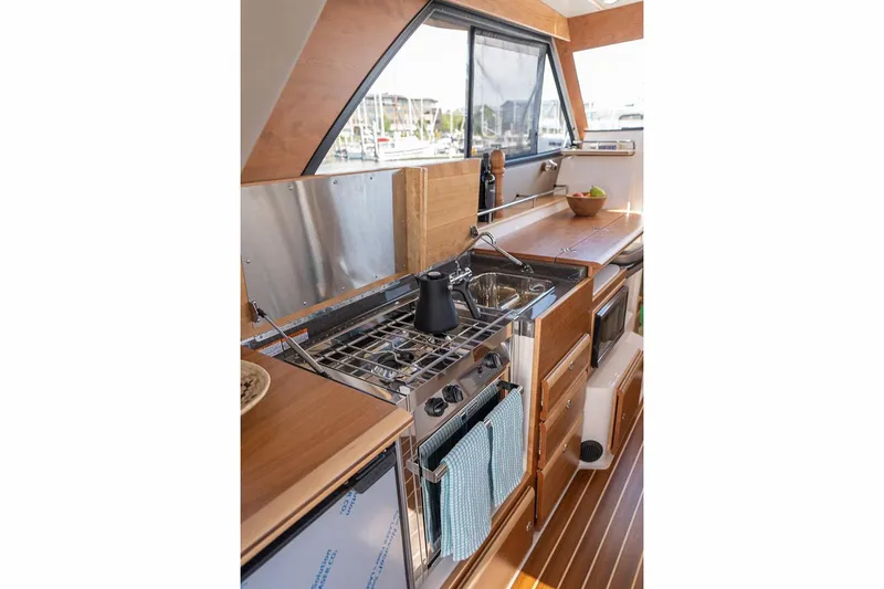 Slide: The Image of Manufacturer Provided Image: 2025 Cutwater C-32 C yacht kitchen interior with modern appliances and wood finish. - 8