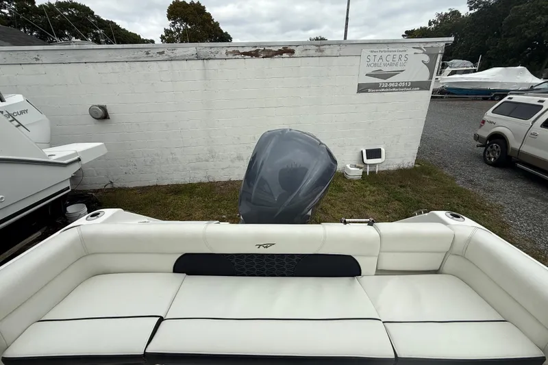 Slide: The Image of 2017 Tidewater 230 LXF boat with white seating and outboard motor in a yard. - 16