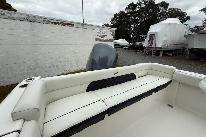Slide: The Image of 2017 Tidewater 230 LXF boat interior with white seating, parked outdoors. - 17