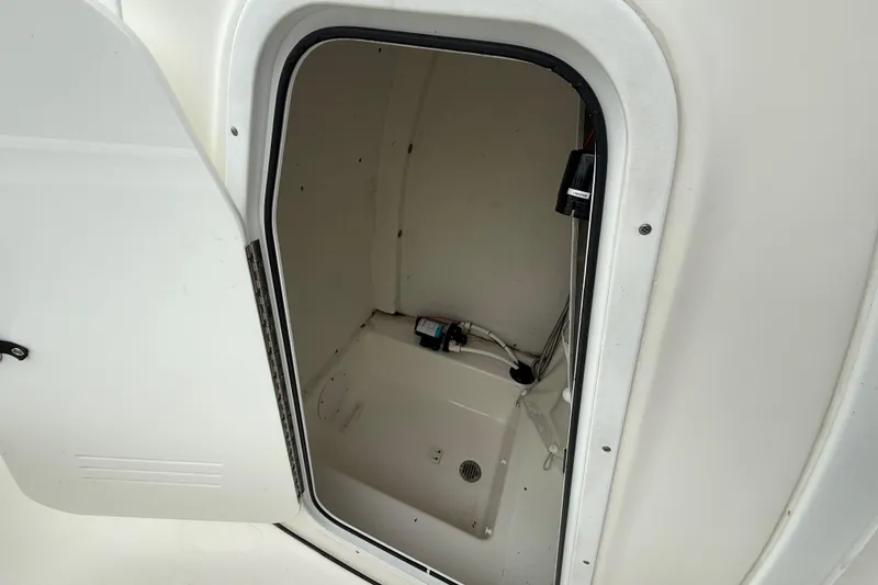 Slide: The Image of 2017 Tidewater 230 LXF boat storage compartment with open door, showcasing interior details. - 19