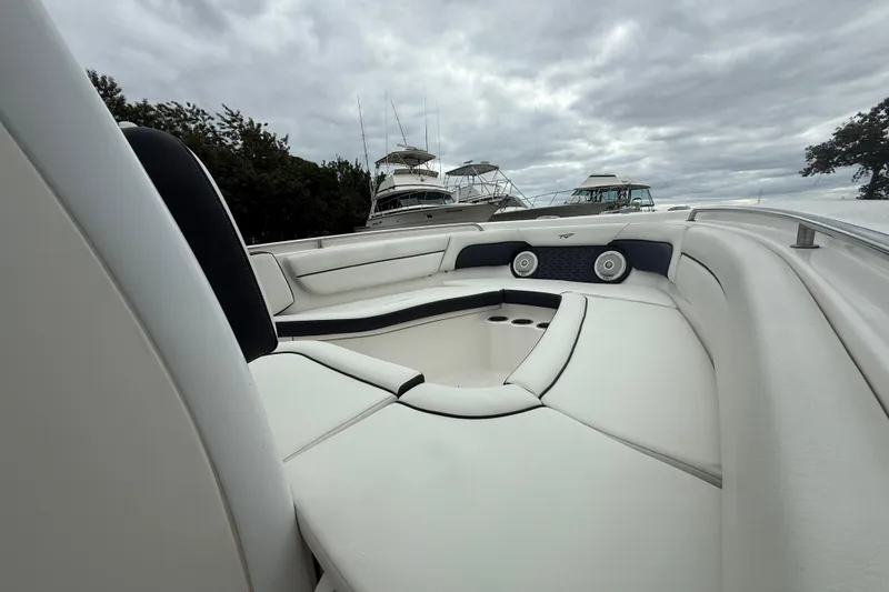 Slide: The Image of 2017 Tidewater 230 LXF boat interior with cushioned seating and overcast sky. - 4