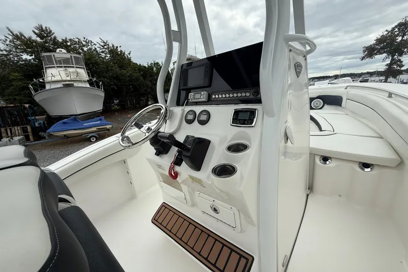 Slide: The Image of 2017 Tidewater 230 LXF boat interior with steering console and seating area. - 8