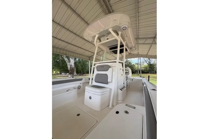 Slide: The Image of 2023 Caymas 26HB boat interior under a canopy, showcasing seating and console. - 2