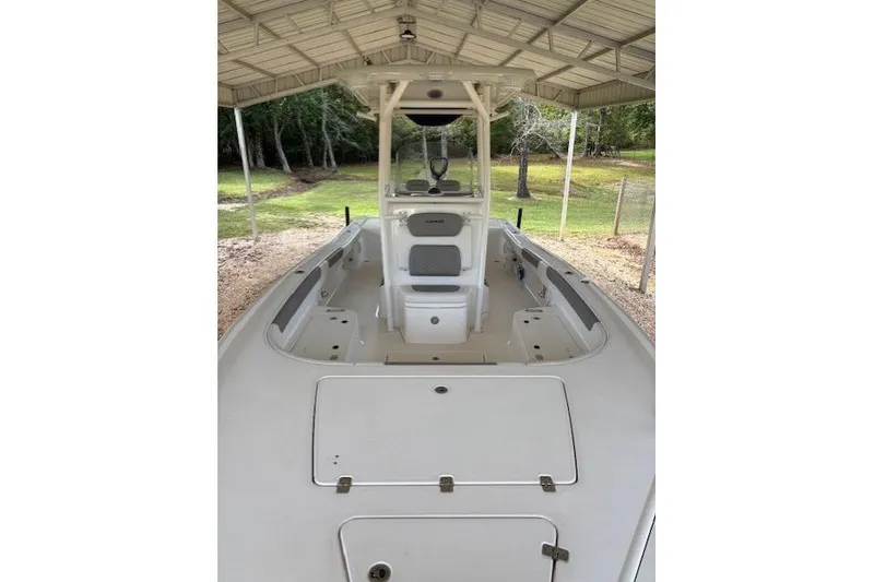 Slide: The Image of 2023 Caymas 26HB boat under a metal canopy, showcasing spacious deck and seating. - 7