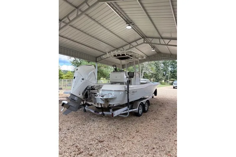 Slide: The Image of 2023 Caymas 26HB boat on trailer under metal canopy, rear view. - 8