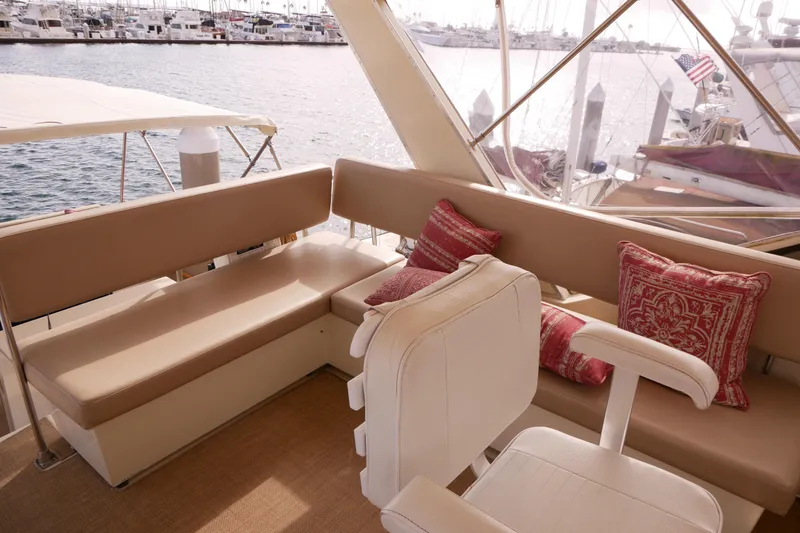 Slide: The Image of 1985 Tollycraft 48 Cockpit Motor Yacht interior with beige seating and decorative pillows. - 11