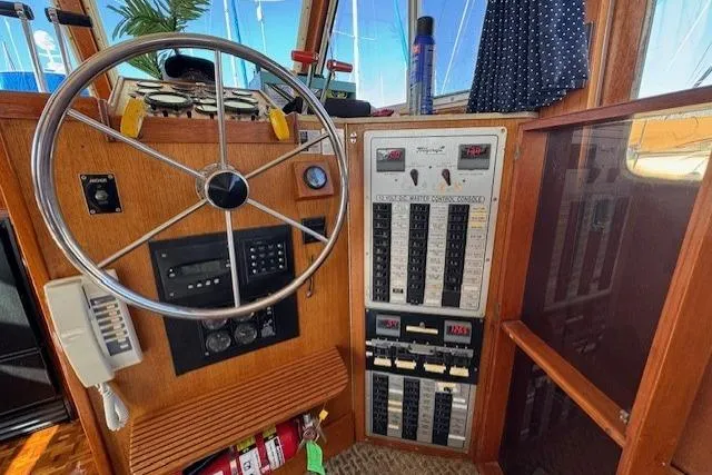 Slide: The Image of 1985 Tollycraft 48 Cockpit Motor Yacht helm with steering wheel and control panel. - 18