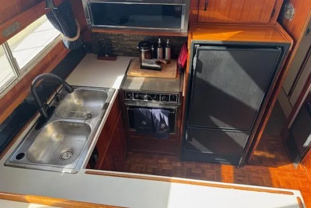 Slide: The Image of 1985 Tollycraft 48 Cockpit Motor Yacht kitchen with sink, stove, and refrigerator. - 25