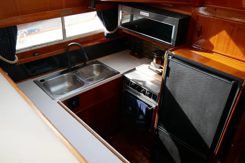 Slide: The Image of 1985 Tollycraft 48 Cockpit Motor Yacht kitchen with sink, stove, and refrigerator. - 27