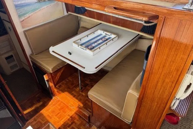 Slide: The Image of 1985 Tollycraft 48 Cockpit Motor Yacht interior with cozy dining area and table. - 31