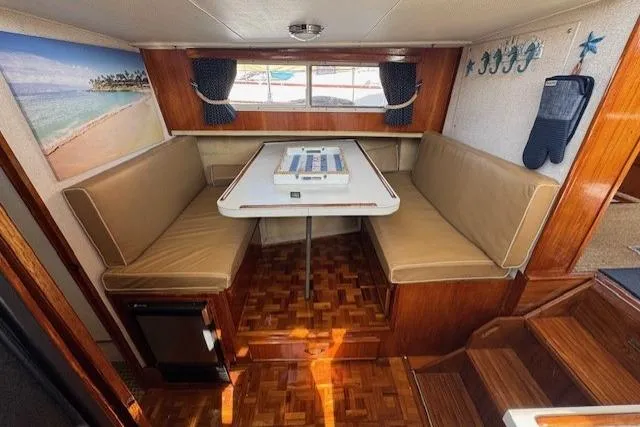 Slide: The Image of 1985 Tollycraft 48 Cockpit Motor Yacht interior with dining area and wood accents. - 32