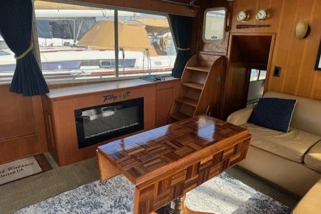 Slide: The Image of 1985 Tollycraft 48 Cockpit Motor Yacht interior with wood accents and cozy seating area. - 34