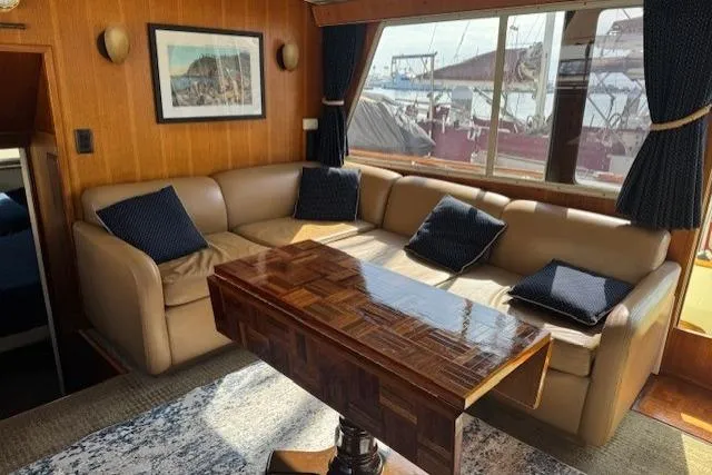 Slide: The Image of 1985 Tollycraft 48 Cockpit Motor Yacht interior with leather seating and wooden table. - 35