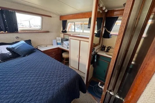 Slide: The Image of 1985 Tollycraft 48 Cockpit Motor Yacht interior with bed, cabinets, and windows. - 38
