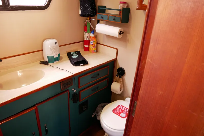 Slide: The Image of 1985 Tollycraft 48 Cockpit Motor Yacht bathroom with sink, toilet, and storage. - 41