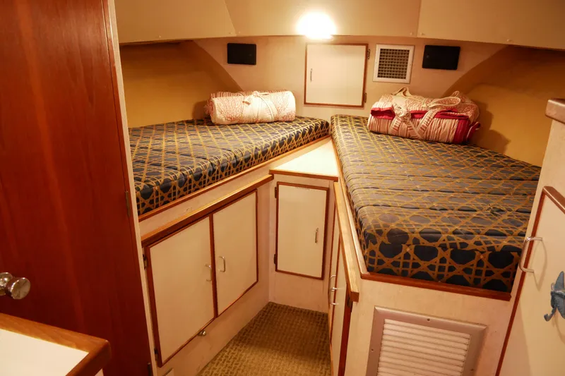 Slide: The Image of 1985 Tollycraft 48 Cockpit Motor Yacht cabin with twin beds and storage cabinets. - 44