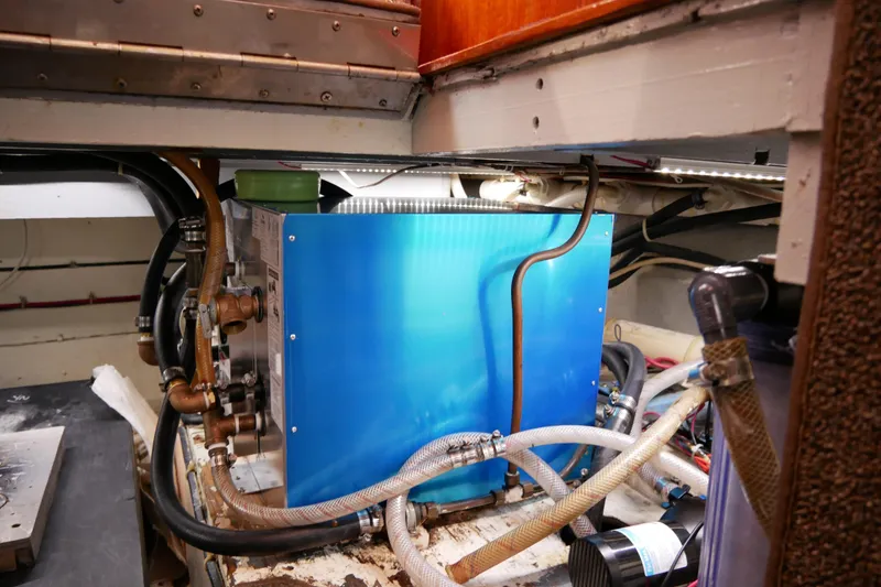 Slide: The Image of Engine room of 1985 Tollycraft 48 Cockpit Motor Yacht with blue machinery and hoses. - 46