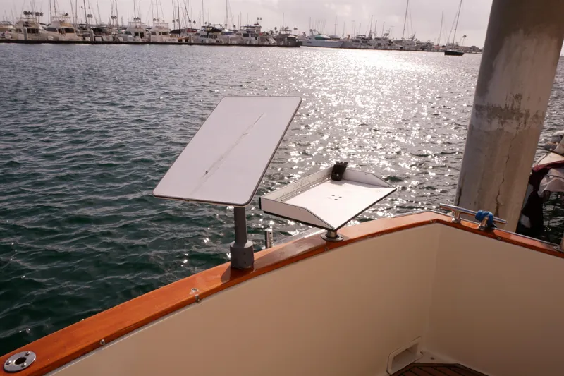 Slide: The Image of 1985 Tollycraft 48 Cockpit Motor Yacht docked with solar panels, marina in background. - 7