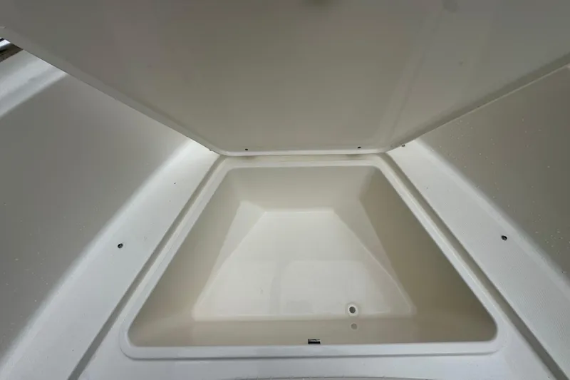 Slide: The Image of 2026 Bulls Bay 230 Center Console storage compartment, open and empty. - 14