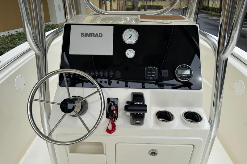 Slide: The Image of 2026 Bulls Bay 230 Center Console boat dashboard with steering wheel and Simrad display. - 8