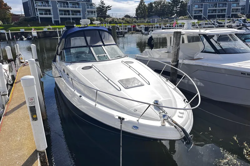 Slide: The Image of 2004 Sea Ray 320 Sundancer docked in a marina, surrounded by modern buildings. - 13