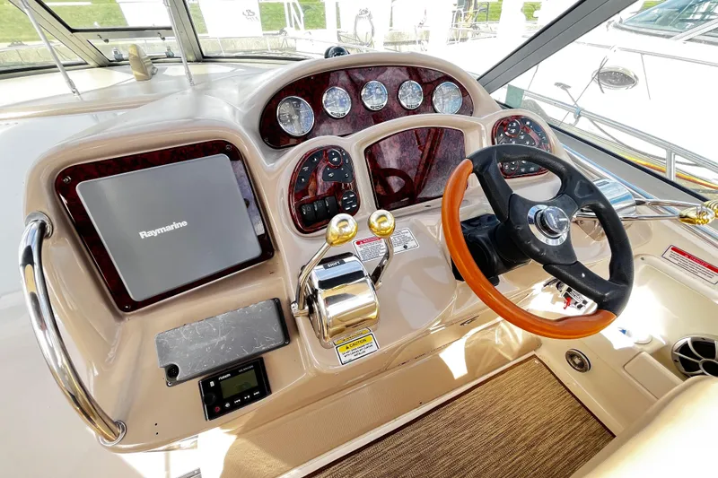 Slide: The Image of Helm of 2004 Sea Ray 320 Sundancer with Raymarine navigation system and wood-accented steering wheel. - 20