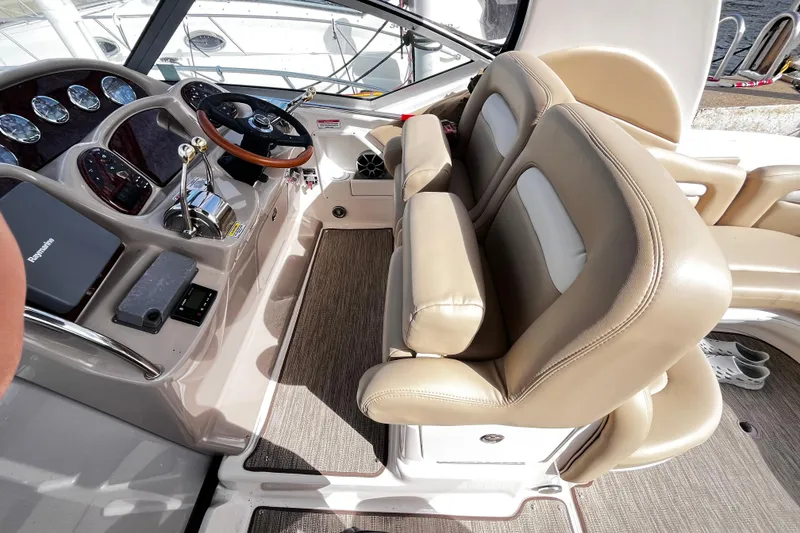 Slide: The Image of 2004 Sea Ray 320 Sundancer helm with beige leather seats and modern controls. - 21