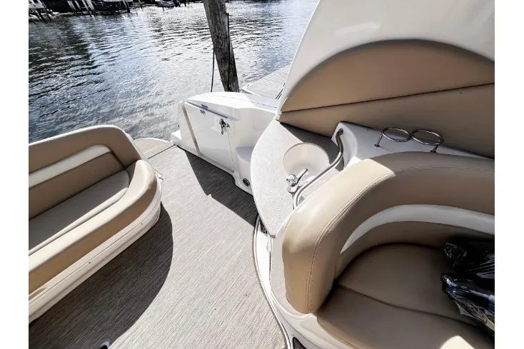 Slide: The Image of 2004 Sea Ray 320 Sundancer boat interior with beige seating and water view. - 3