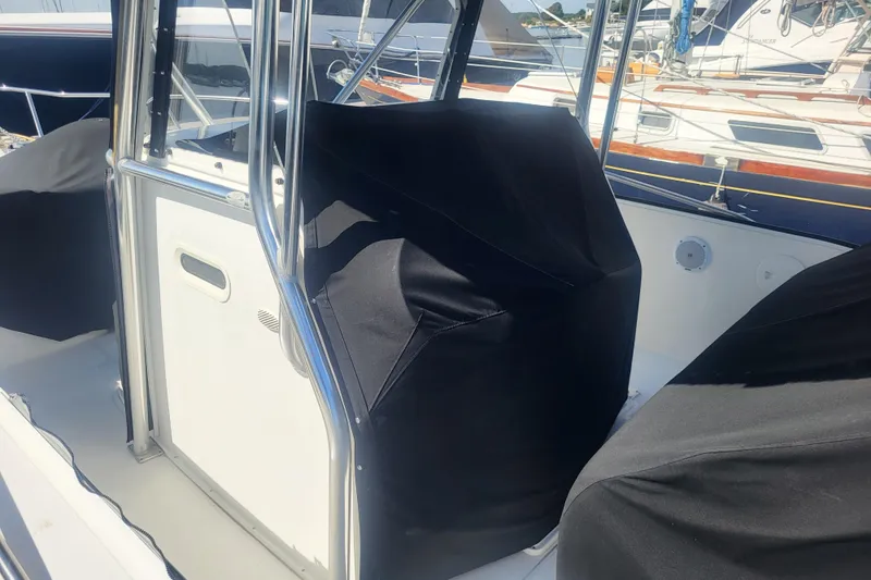 Slide: The Image of 2005 Stamas 310 Tarpon boat interior with covered seating and stainless steel railings. - 11