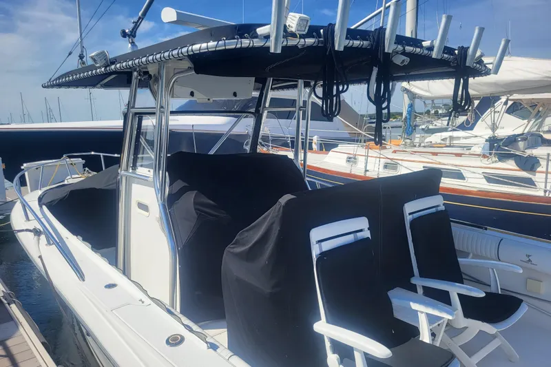 Slide: The Image of 2005 Stamas 310 Tarpon boat docked, featuring covered seating and fishing rod holders. - 12
