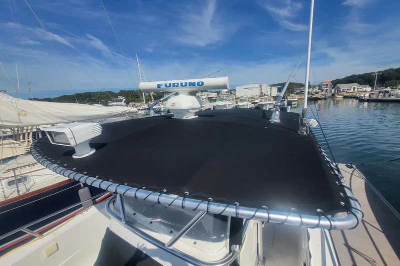 Slide: The Image of 2005 Stamas 310 Tarpon boat docked, featuring radar equipment under a clear blue sky. - 14