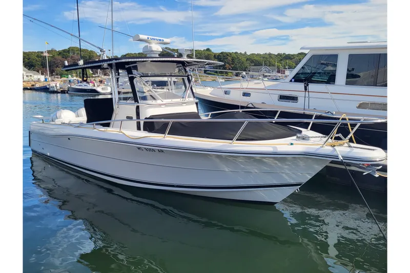 Slide: The Image of 2005 Stamas 310 Tarpon boat docked in a marina, clear sky background. - 2