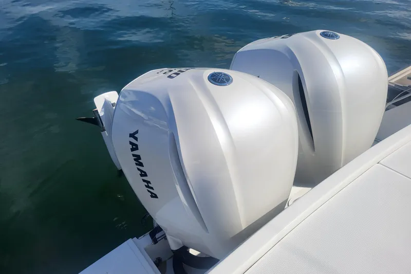 Slide: The Image of Twin Yamaha outboard engines on a 2005 Stamas 310 Tarpon boat, docked on calm water. - 21