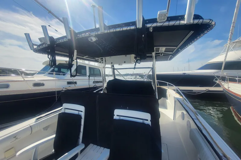 Slide: The Image of 2005 Stamas 310 Tarpon boat docked, featuring a spacious deck and overhead canopy. - 23
