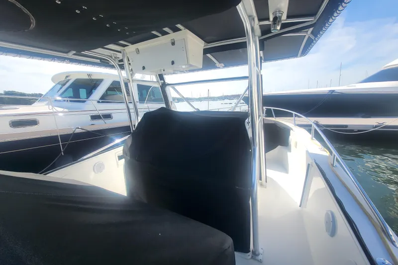 Slide: The Image of 2005 Stamas 310 Tarpon boat interior with canopy, docked alongside other vessels. - 24