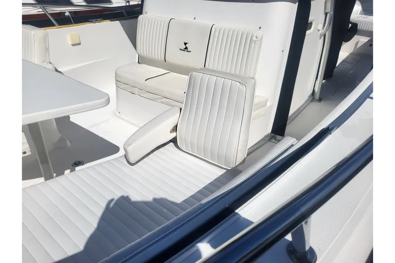 Slide: The Image of 2005 Stamas 310 Tarpon boat interior with white cushioned seating and table. - 33