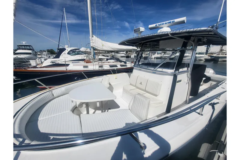 Slide: The Image of 2005 Stamas 310 Tarpon boat with spacious seating and table, docked at a marina. - 36
