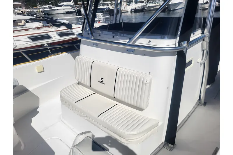 Slide: The Image of 2005 Stamas 310 Tarpon boat interior with cushioned seating and marina background. - 38