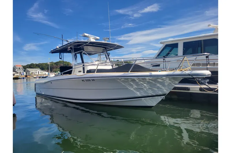Slide: The Image of 2005 Stamas 310 Tarpon boat docked in a marina under a clear blue sky. - 4