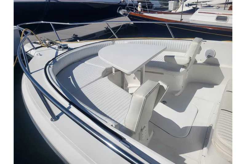 Slide: The Image of 2005 Stamas 310 Tarpon boat interior with white seating and table, docked at marina. - 40