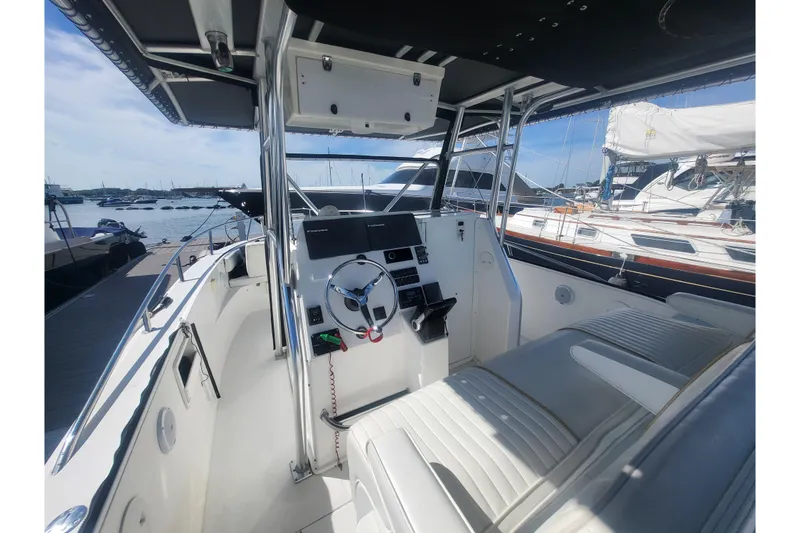 Slide: The Image of 2005 Stamas 310 Tarpon boat interior with steering wheel and seating, docked at marina. - 44