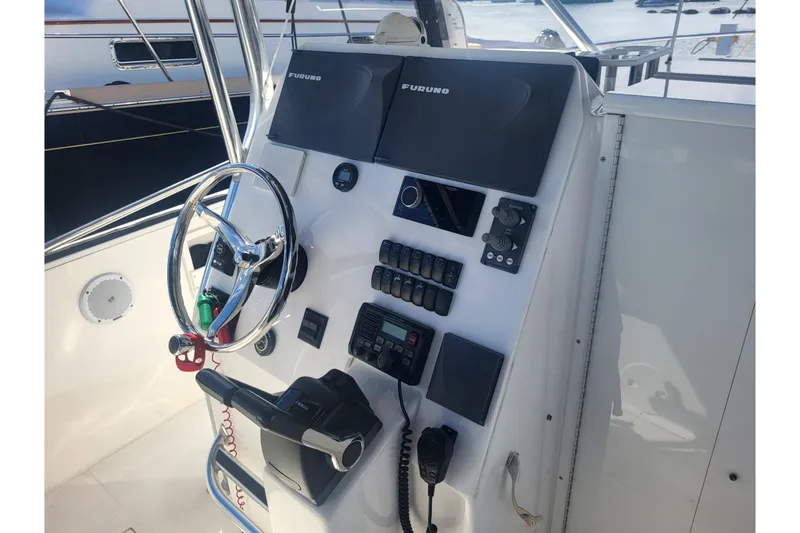 Slide: The Image of 2005 Stamas 310 Tarpon boat helm with steering wheel and navigation controls. - 47